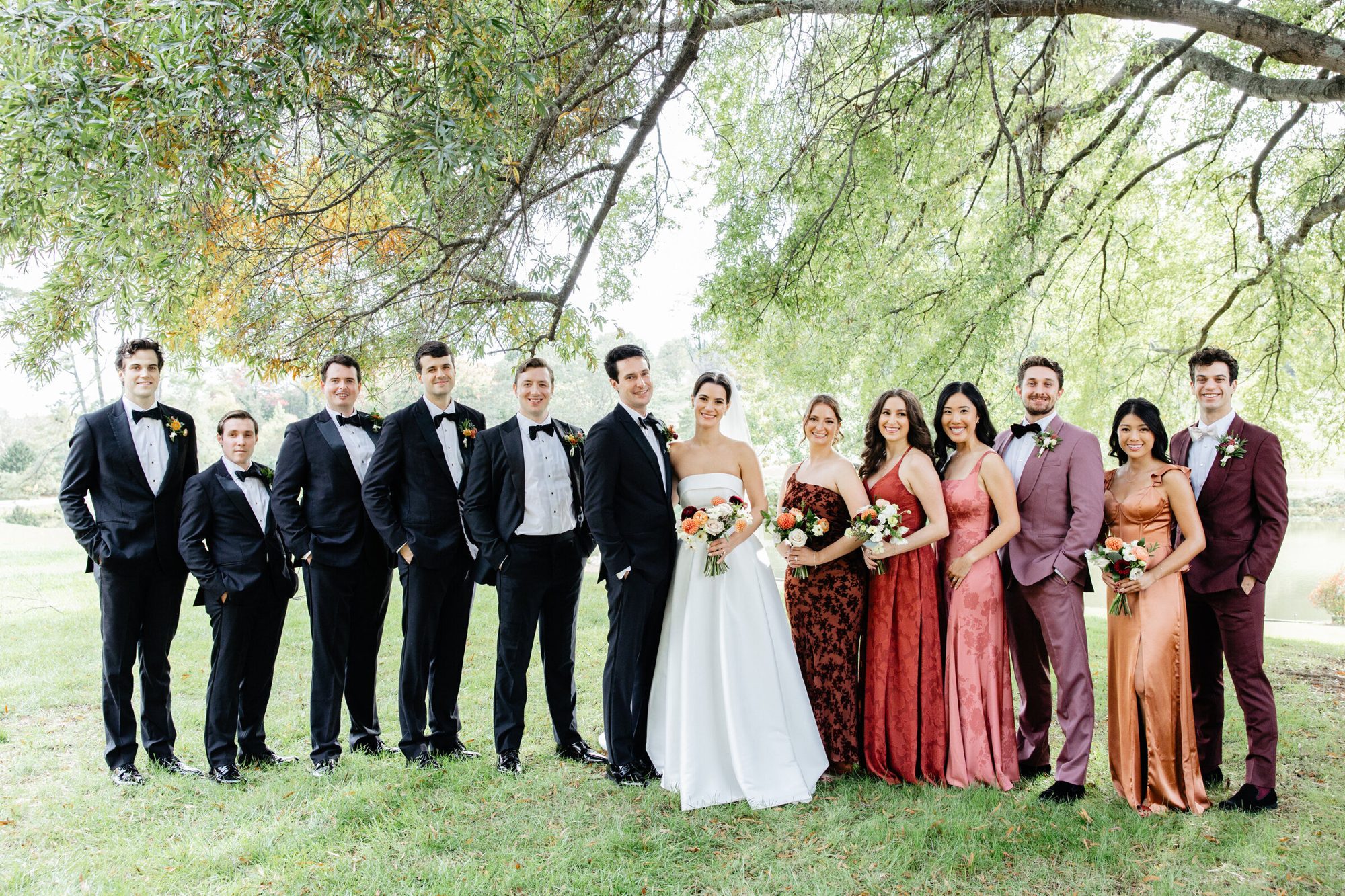 Full wedding party on the lawn under the trees at Boars Head Resort