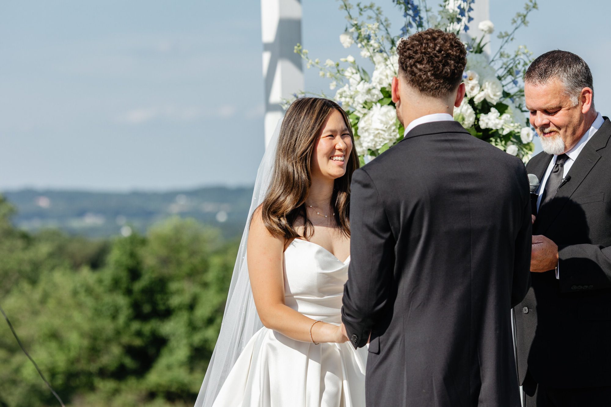 Bride smiling at the groom during the ceremony at The View at Bluemont