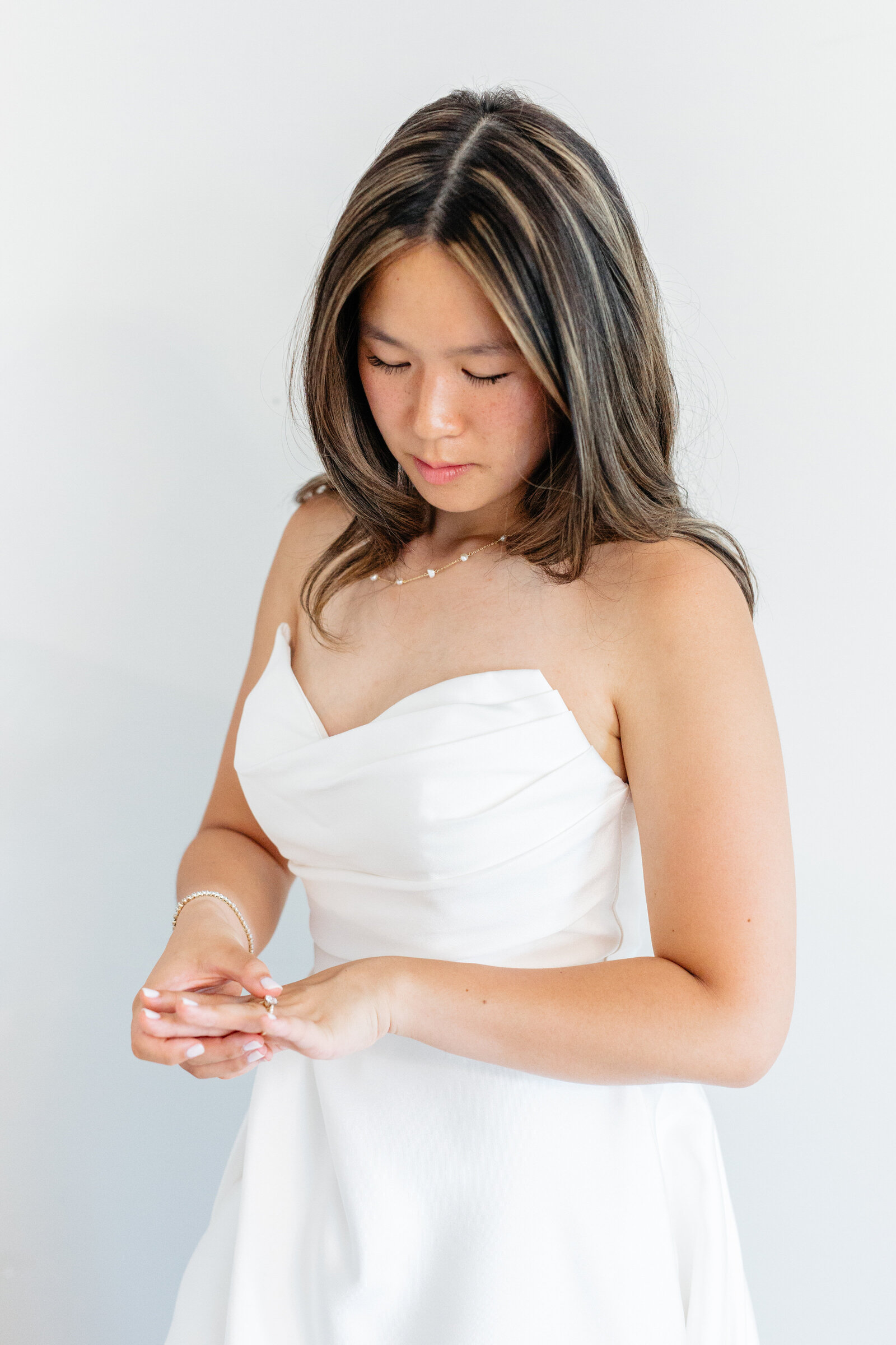Bride looking down in her strapless gown at The View at Bluemont