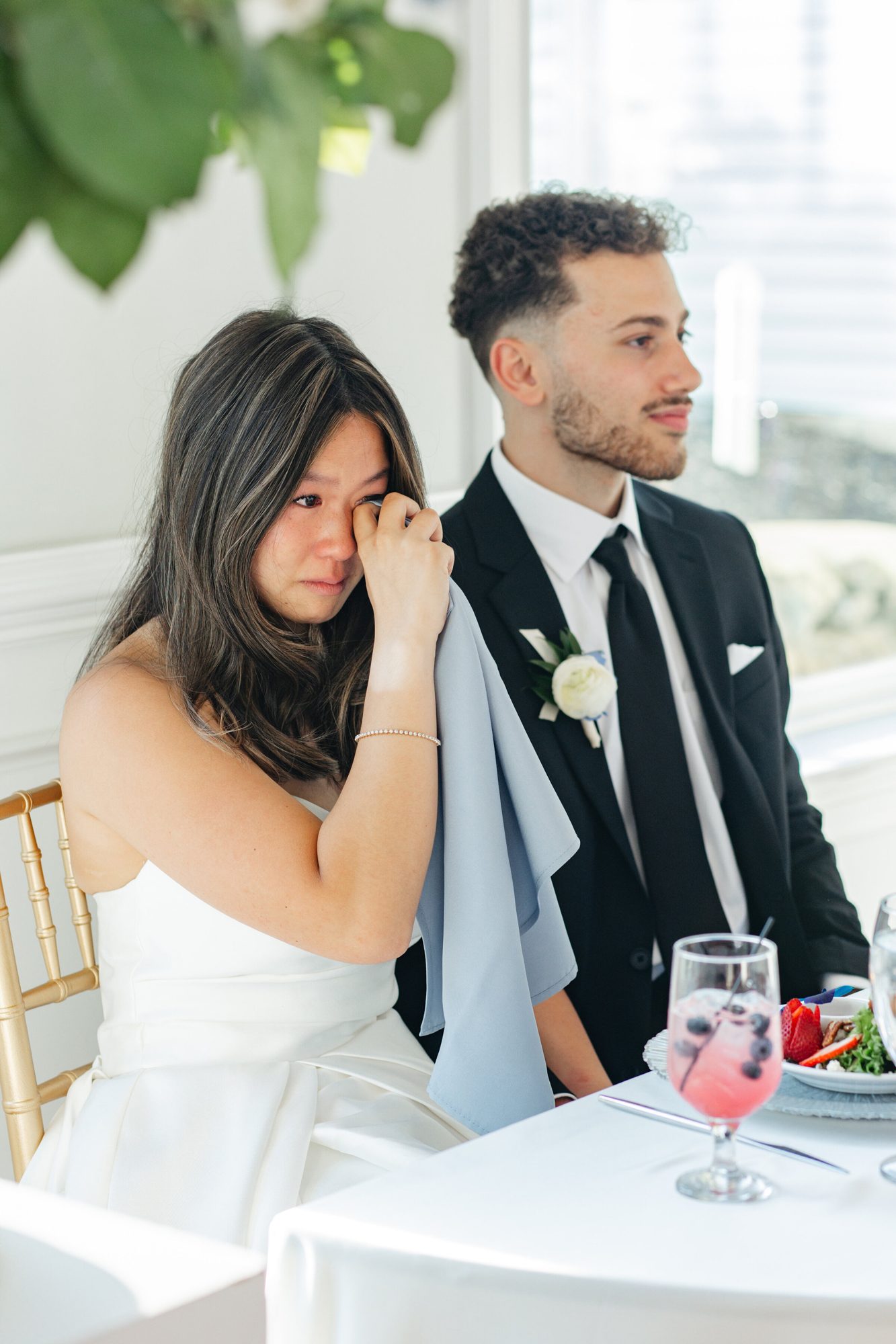 Bride wiping a tear at the reception table at The View at Bluemont