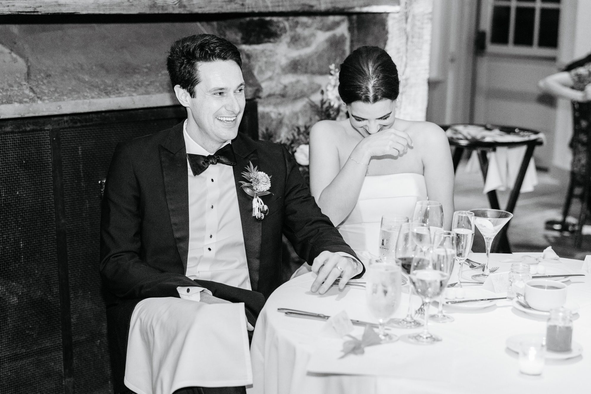 Black-and-white photo of the bride laughing at the head table at Boars Head Resort