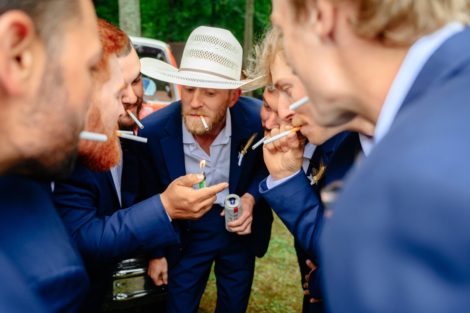 Groomsmen laughing and sharing a drink together before the wedding