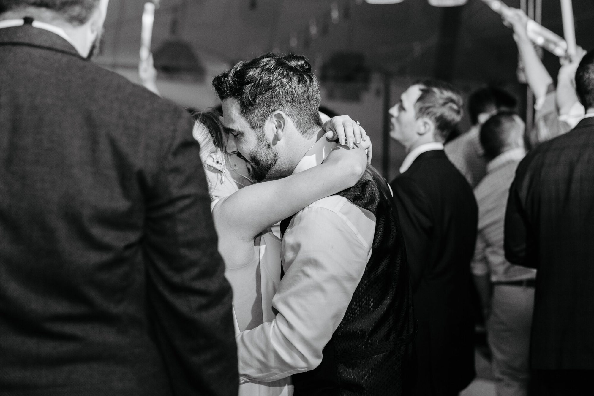 Black-and-white photo of the groom hugging a guest at Historic Whitewood