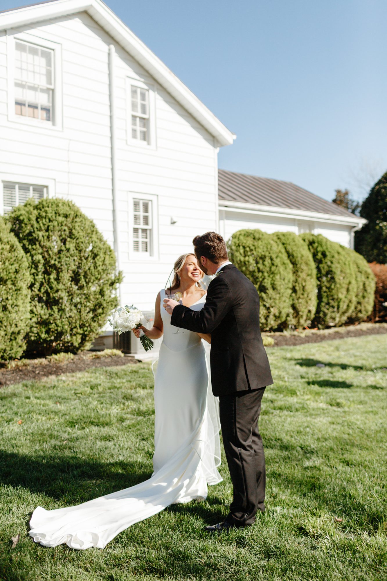 Couple kissing on the lawn beside the house at Historic Whitewood