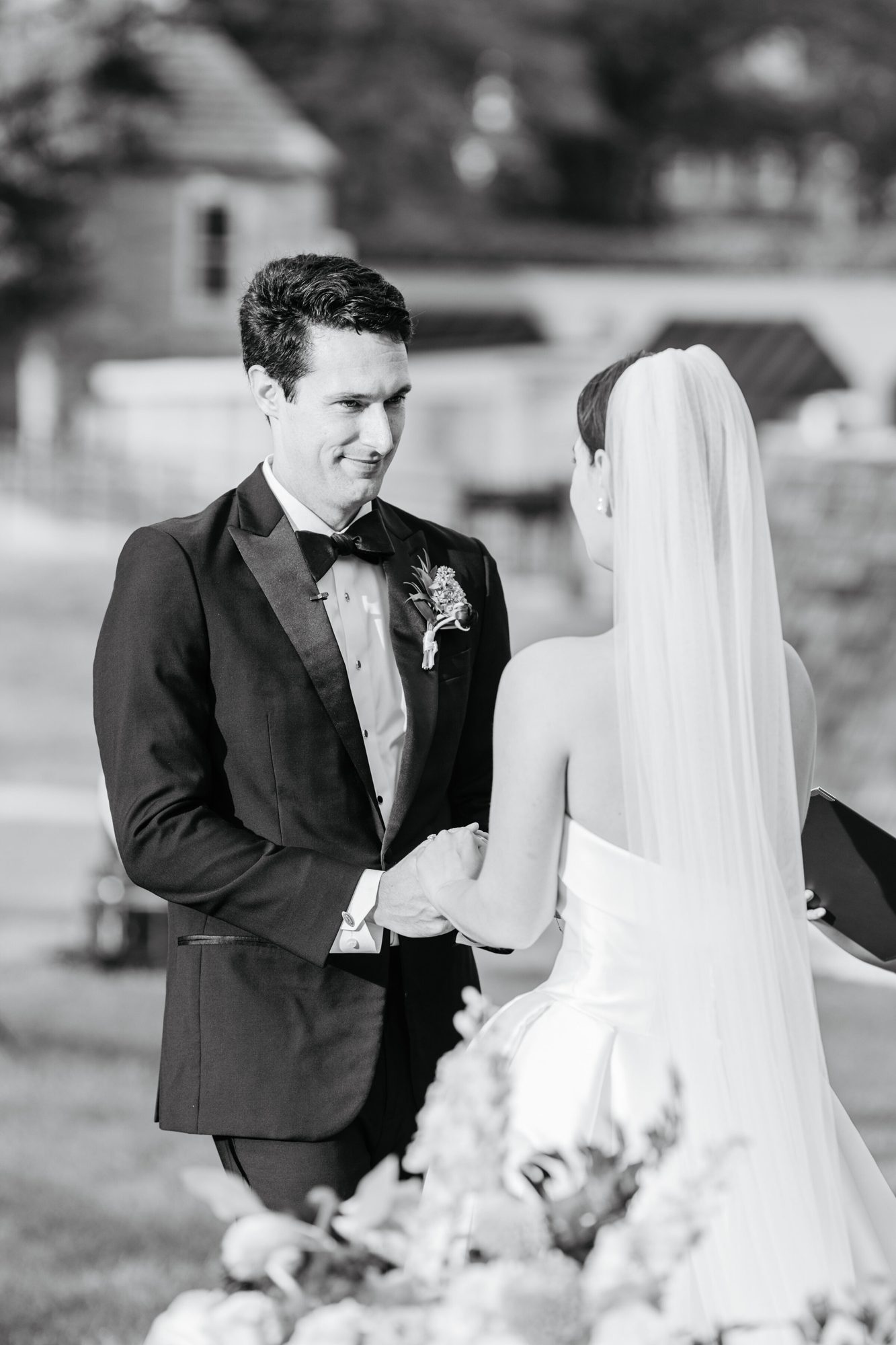 Black-and-white photo of the groom smiling at the bride during the ceremony at Boars Head Resort