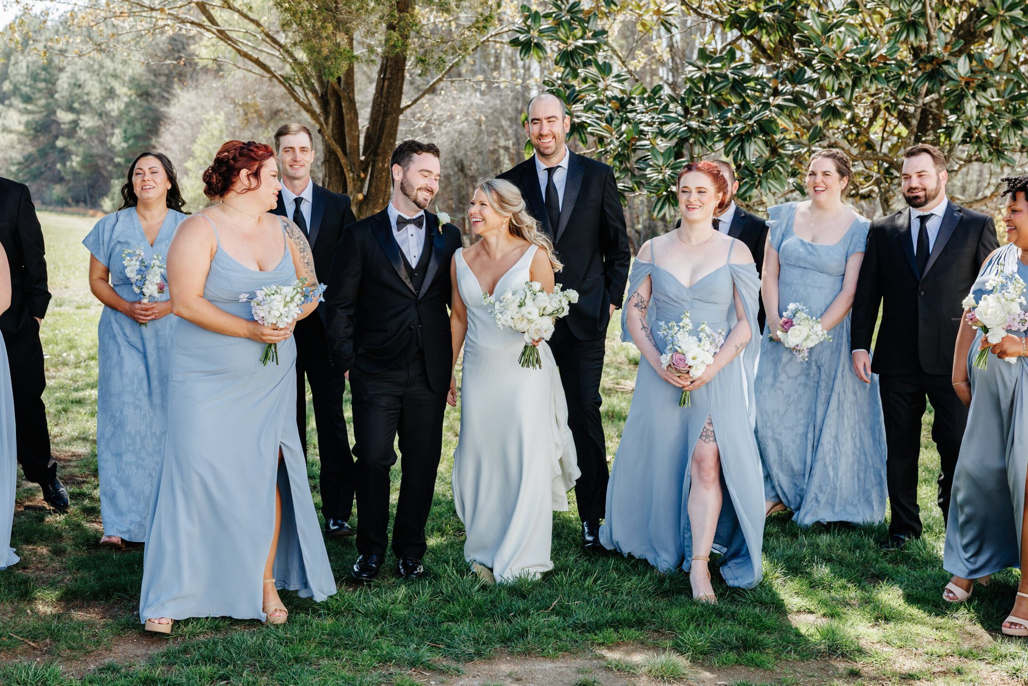 Bride and bridesmaids laughing together on the lawn at Historic Whitewood