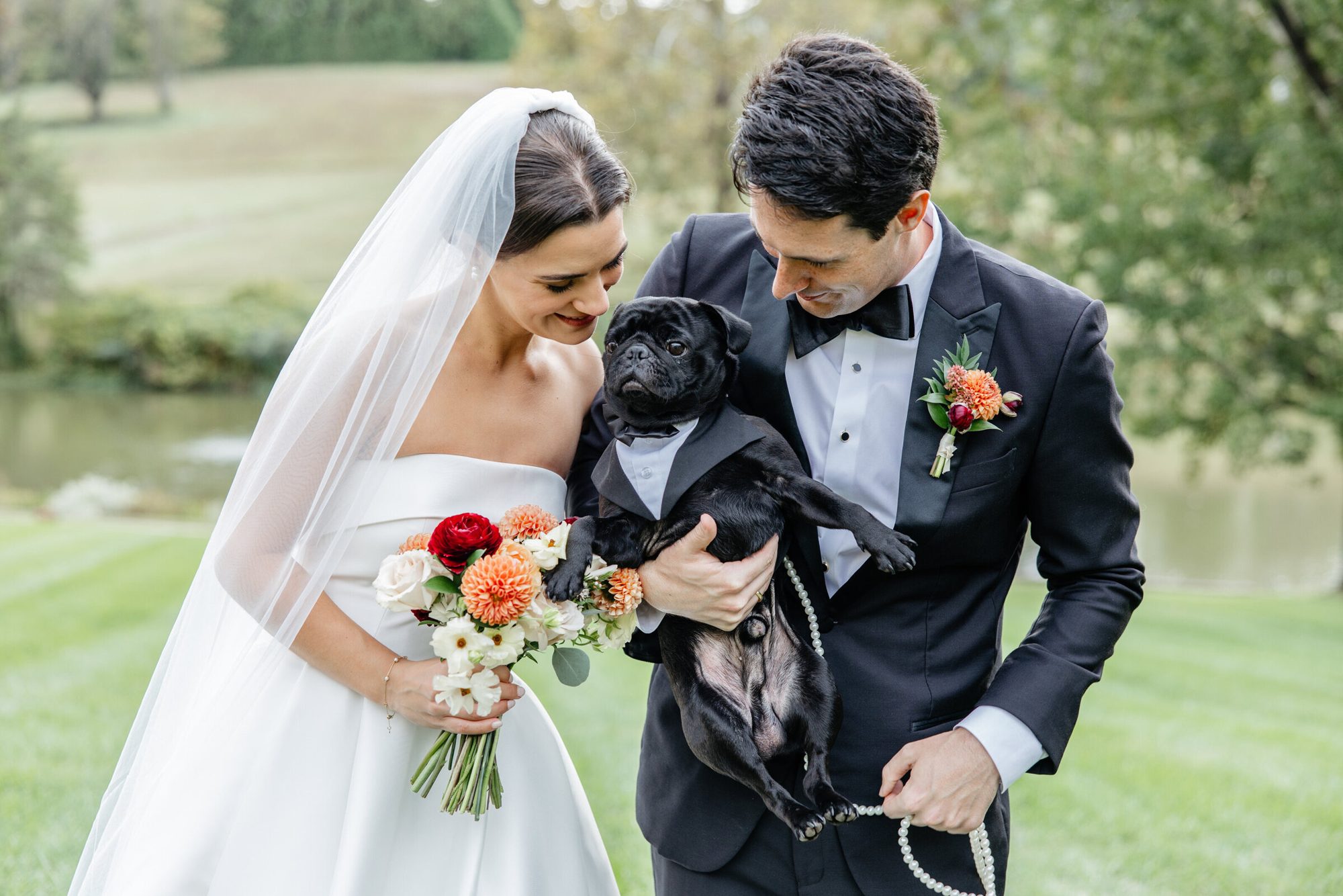 Couple laughing with their dog in a tuxedo at Boars Head Resort