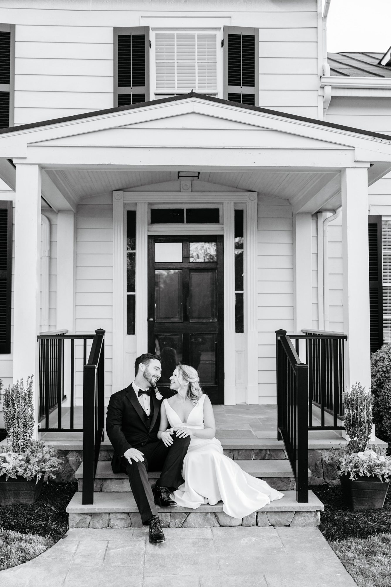 Black-and-white photo of the couple on the front steps at Historic Whitewood at Historic Whitewood