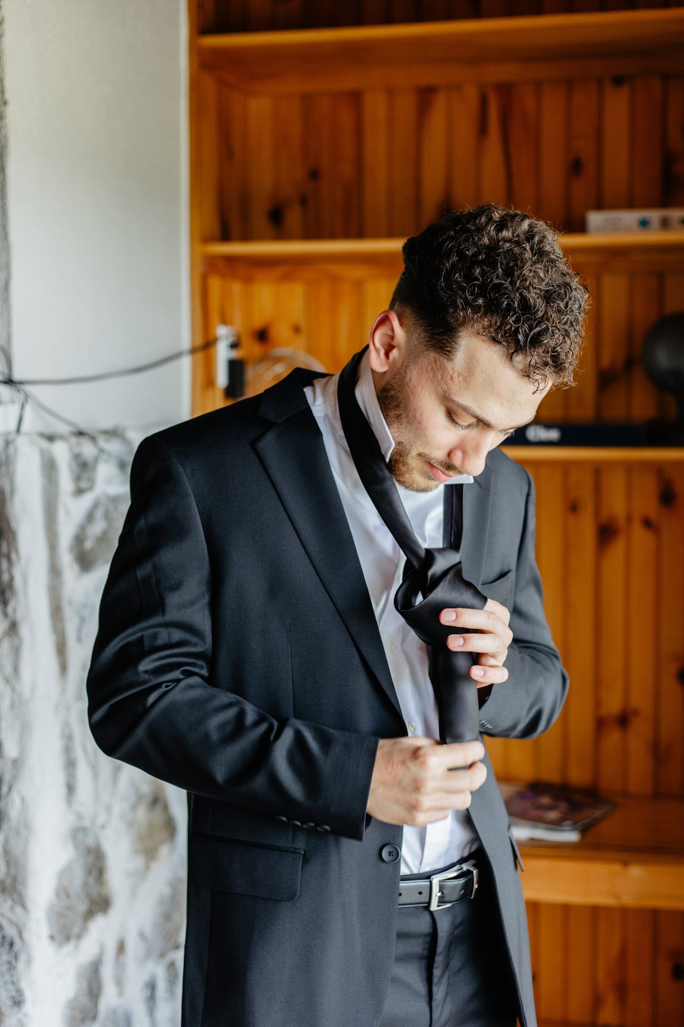 Groom tying his bow tie at The View at Bluemont