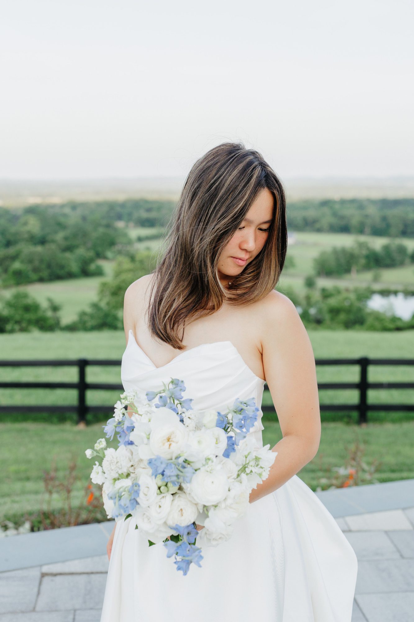 Bride holding her bouquet with countryside behind her at The View at Bluemont