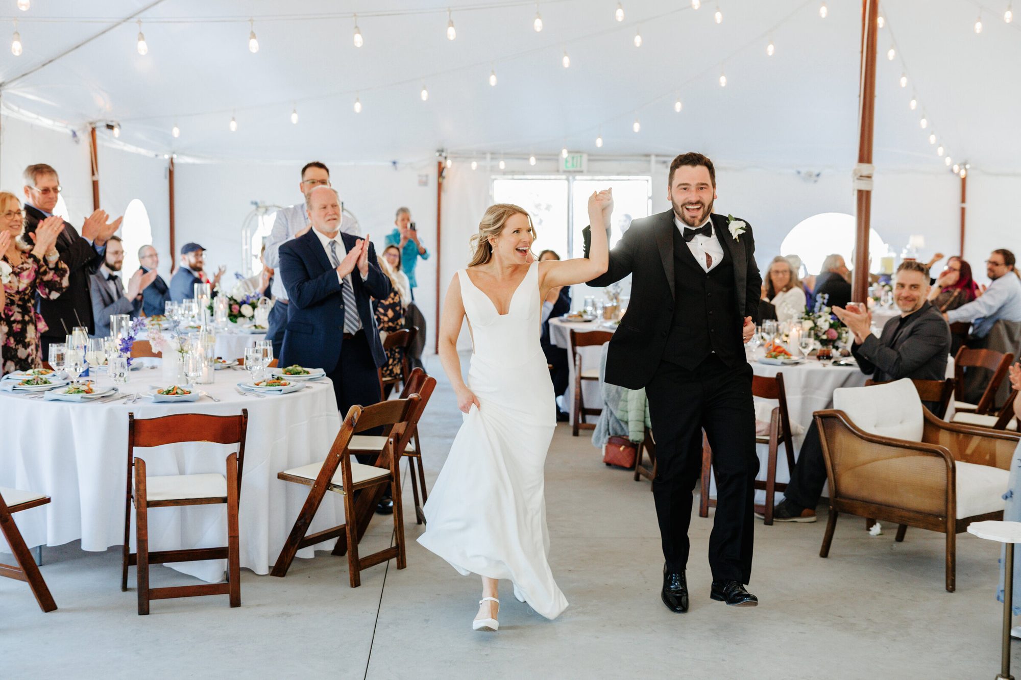 Couple entering the reception tent as guests cheer at Historic Whitewood