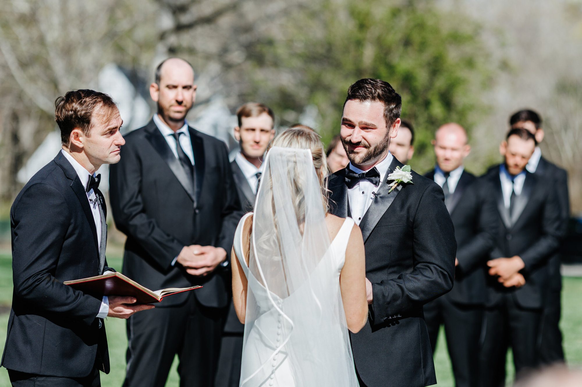 Groom and groomsmen reacting during the ceremony at Historic Whitewood
