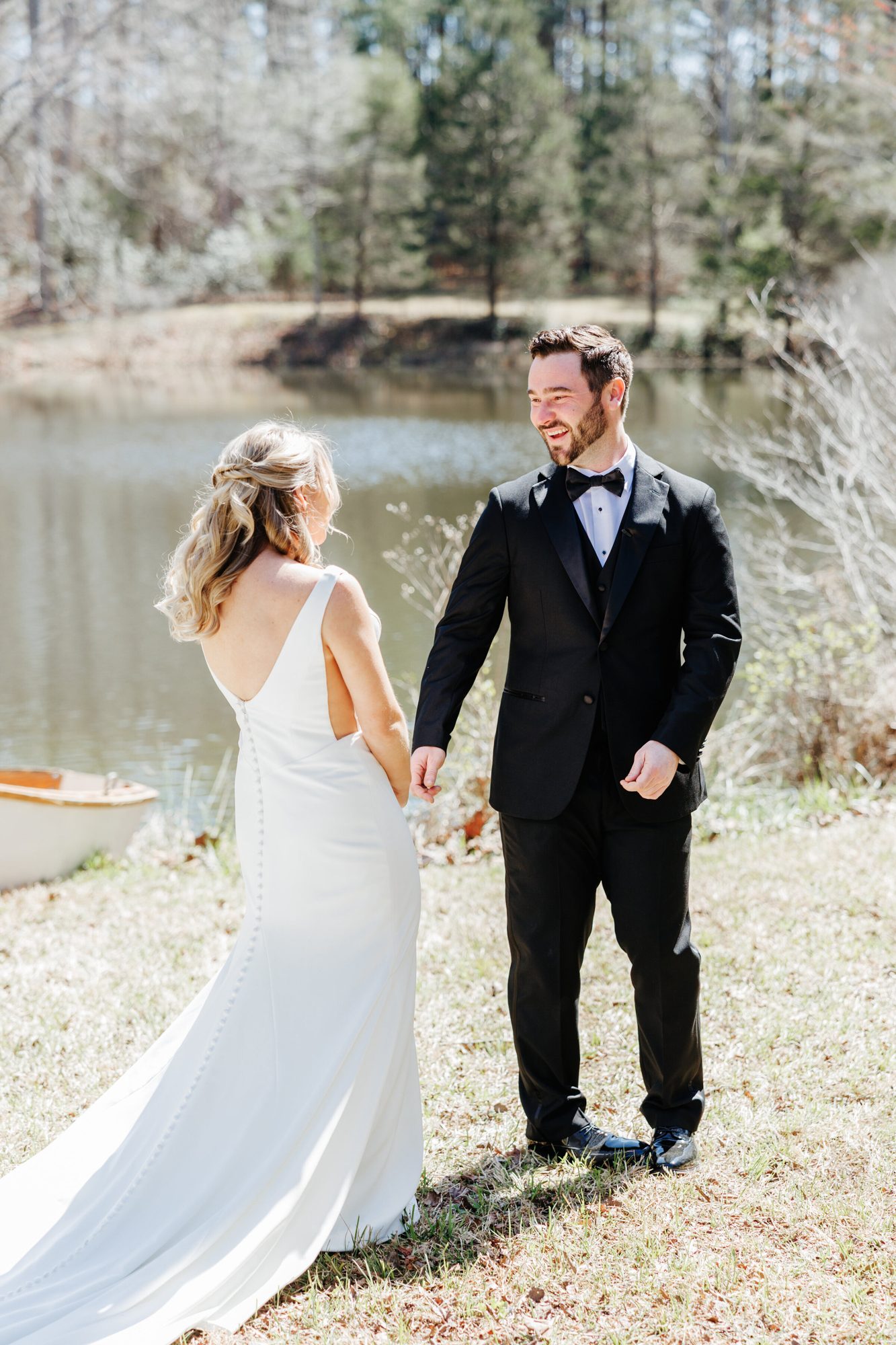 Groom turning to see the bride by the pond for their first look at Historic Whitewood