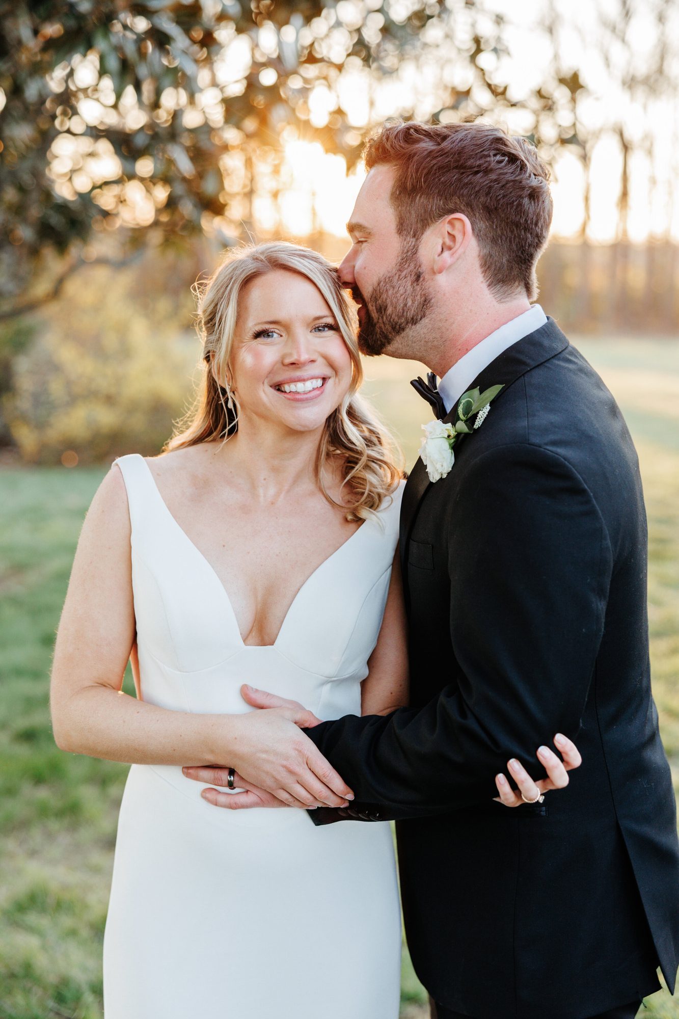 Groom kissing the bride’s cheek in golden light at Historic Whitewood