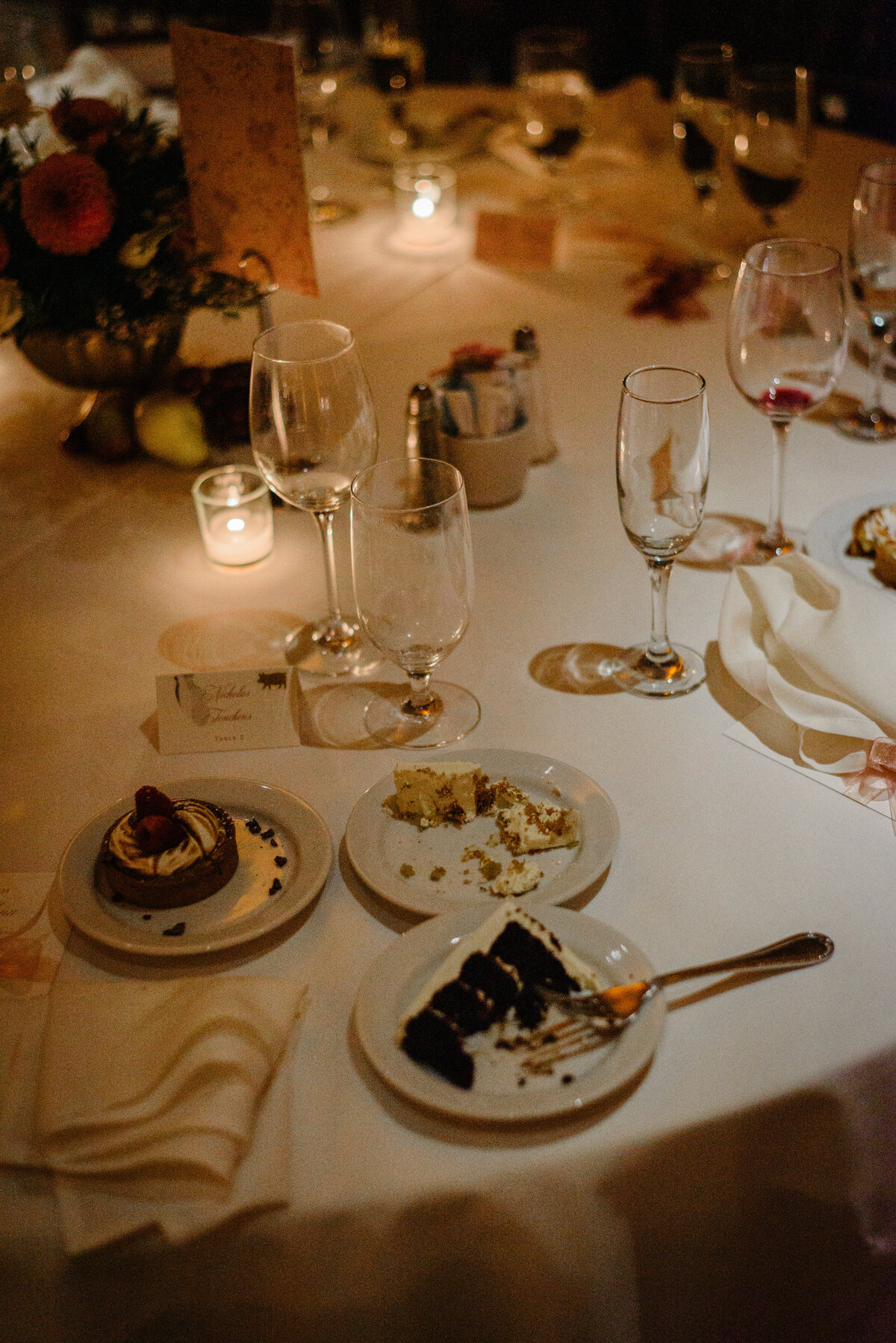 Candlelit wedding reception table with place settings and flowers