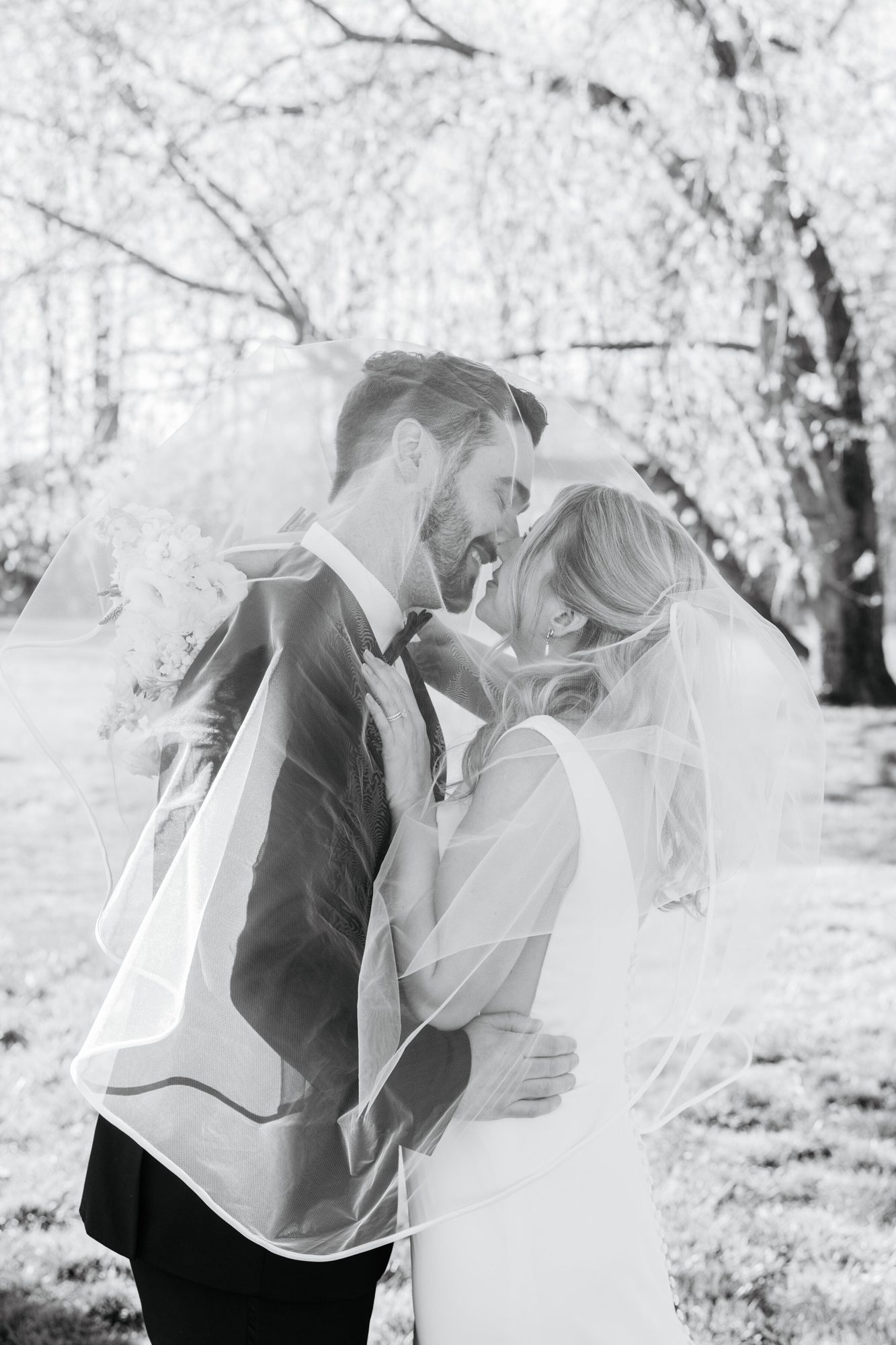 Black-and-white photo of the couple kissing under the veil at Historic Whitewood
