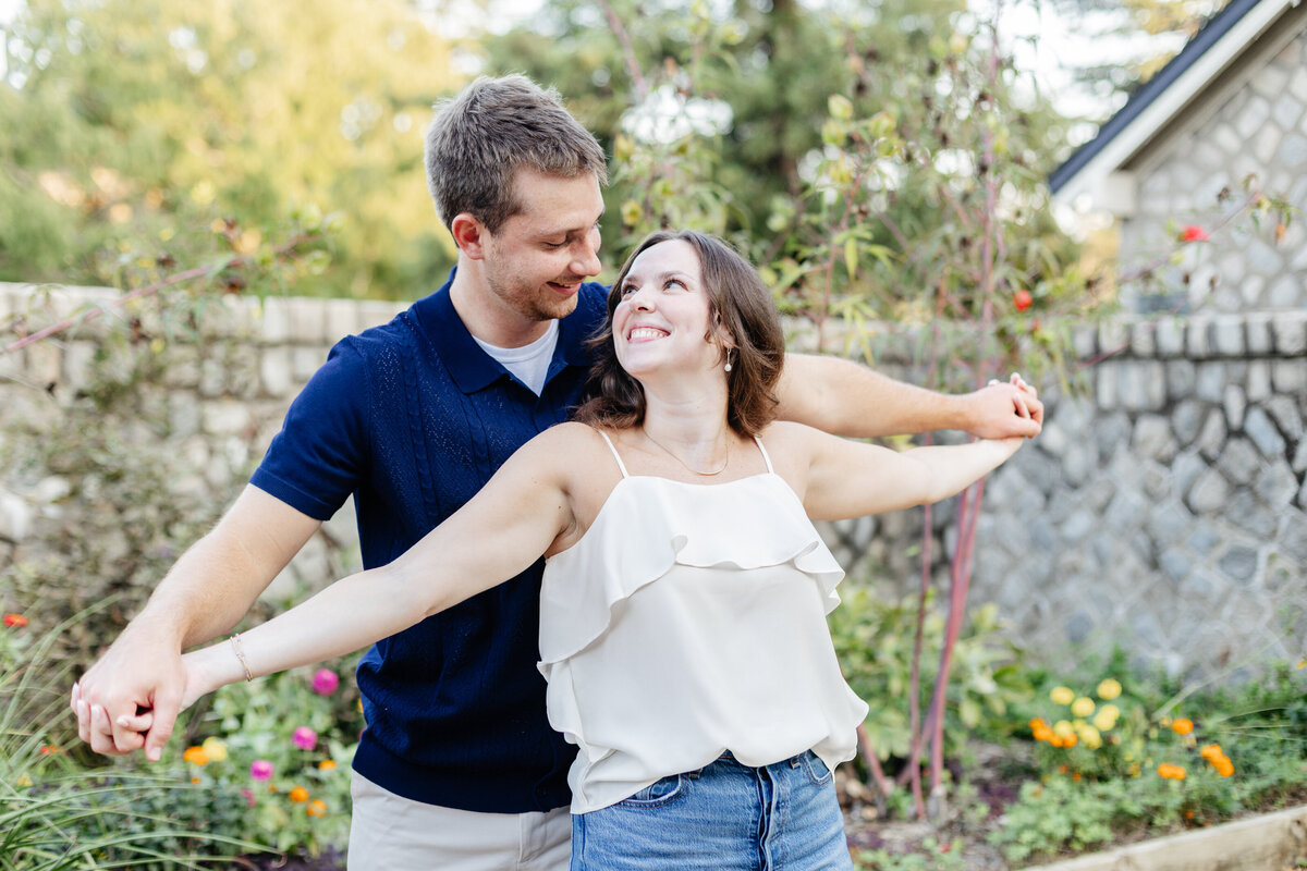 Engaged couple smiling and dancing together outdoors