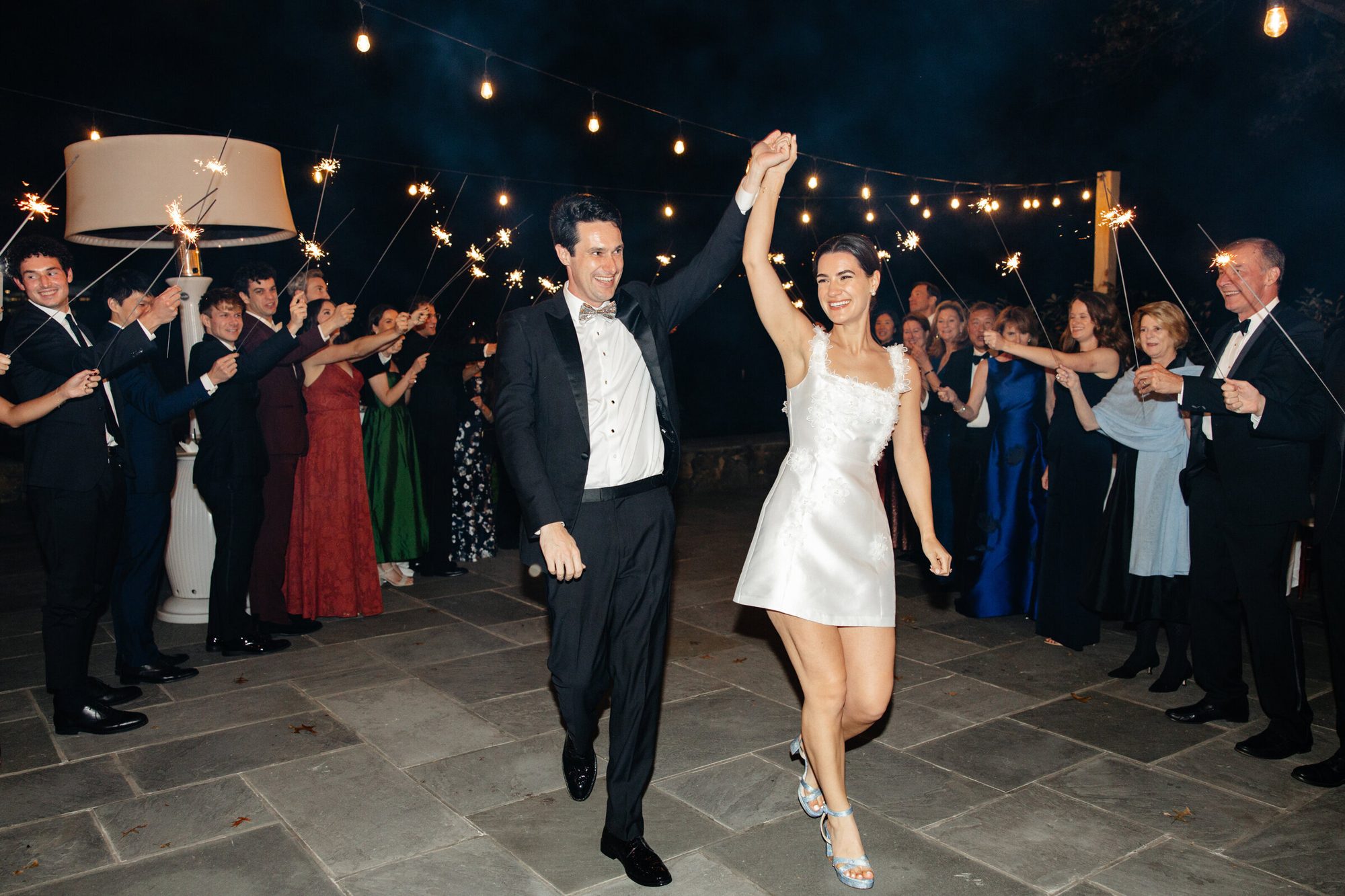 Couple dancing through guests under string lights at Boars Head Resort