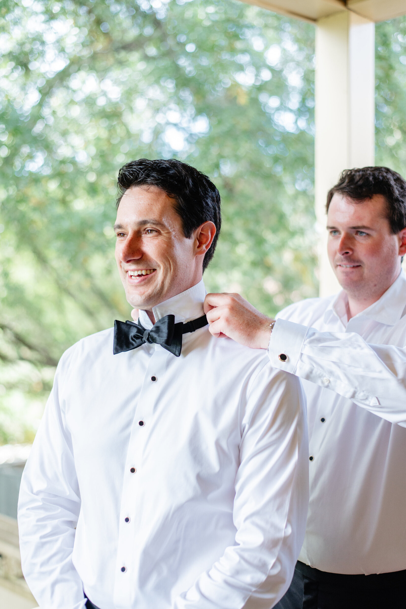 Groom getting ready with help on his bow tie at Boars Head Resort
