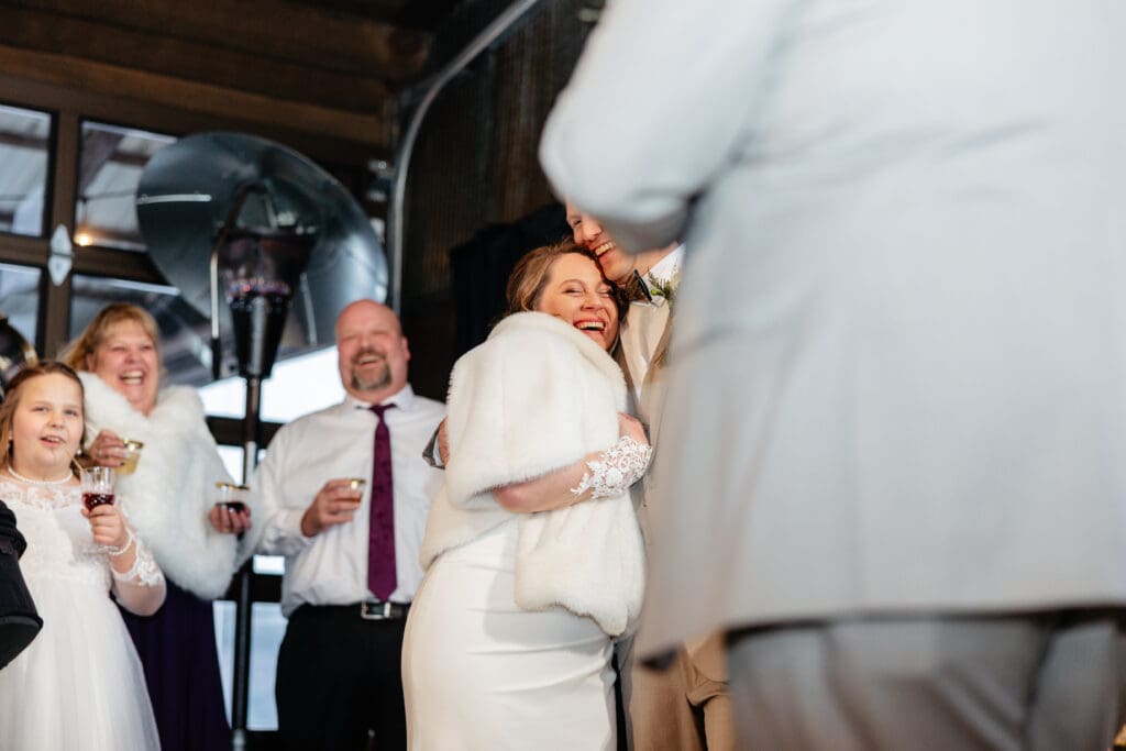A videographer filming a couple during their reception, capturing footage for either a highlight film vs documentary style edit.