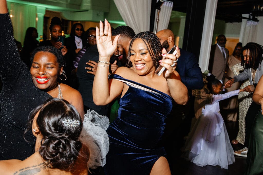 Wedding guests taking photos during a reception, illustrating helpful wedding guest photo tips for your big day.